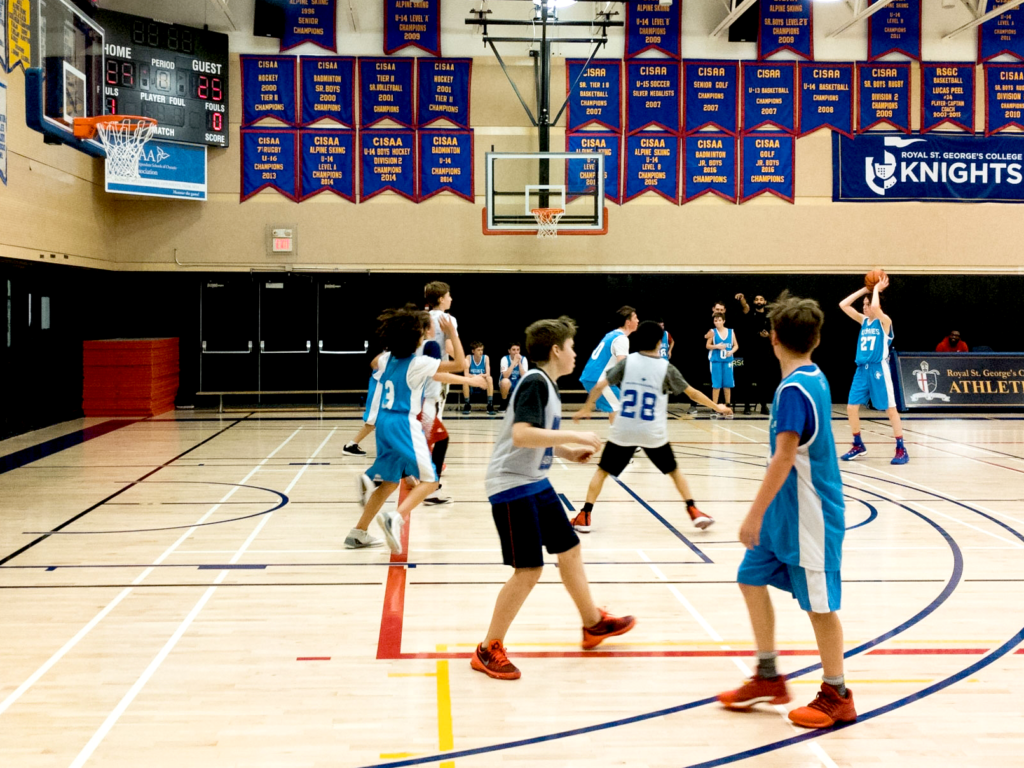 Students playing basketball with the Huskies initiating their half-court offence