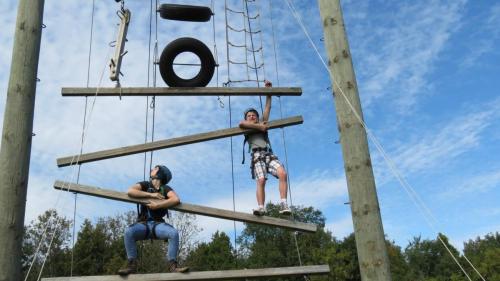 Students climbing tower structure