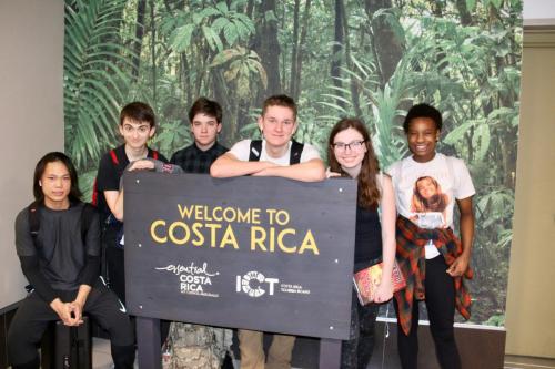 Students with Welcome to Costa Rica sign